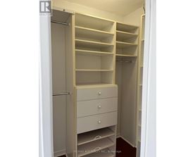 A white closet with shelves and drawers is shown.