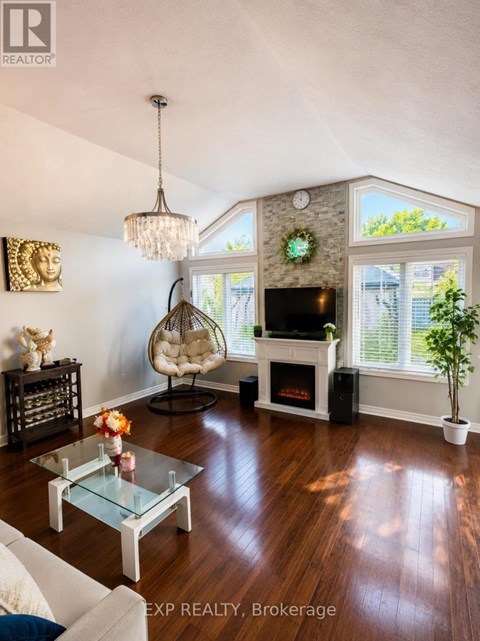 A living room with a glass coffee table and a fireplace.