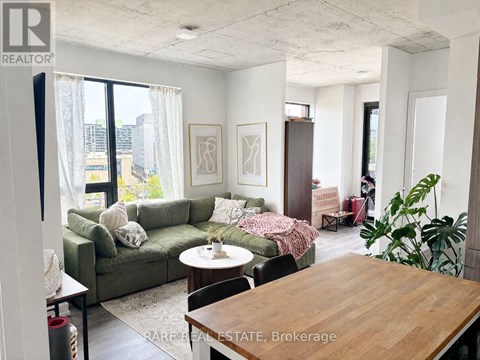 A living room with a couch, a chair, a table and a potted plant.