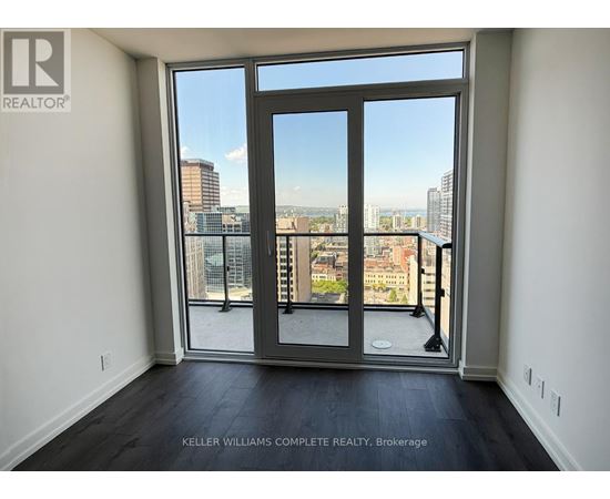 A room with a view of the city through a large window.
