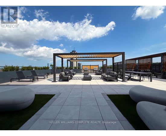 A modern outdoor seating area with a white and grey tiled floor and a wooden pergola.