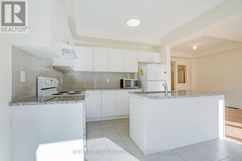 A kitchen with white cabinets and a granite countertop.