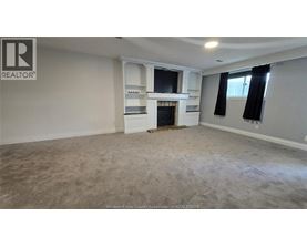 A spacious living room with a fireplace and built-in shelves.