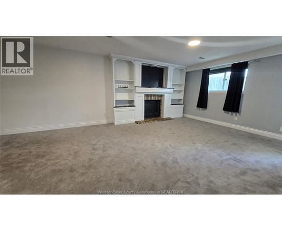 A spacious living room with a fireplace and built-in shelves.