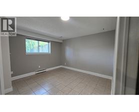 A room with a window and a tiled floor.