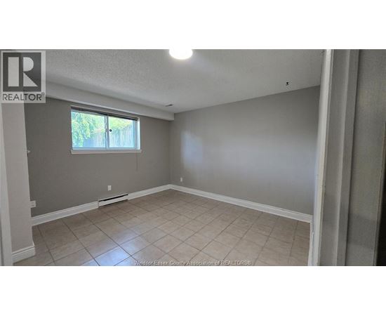 A room with a window and a tiled floor.