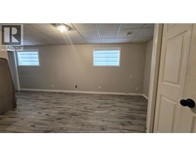 A room with a wooden floor and a door on the right side.