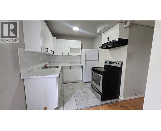 A kitchen with white cabinets and a black stove top oven.