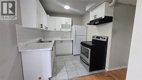 A kitchen with white cabinets and a black stove top oven.
