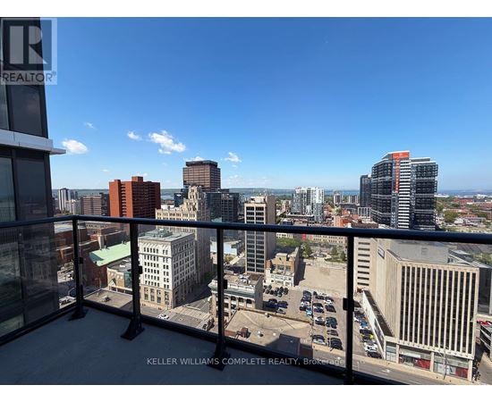 A cityscape viewed from a high-rise building with a clear blue sky.