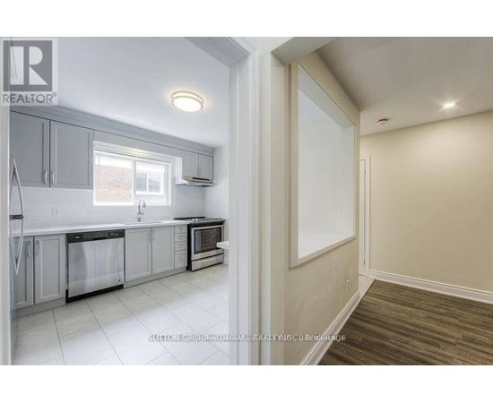 A kitchen with white cabinets and a window.