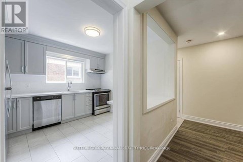 A kitchen with white cabinets and a window.