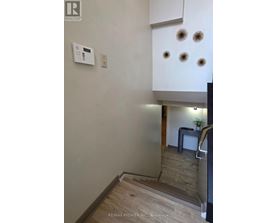 A white wall with a thermostat and four lights on it.