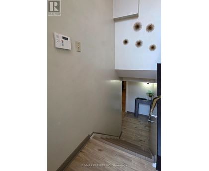 A white wall with a thermostat and four lights on it.