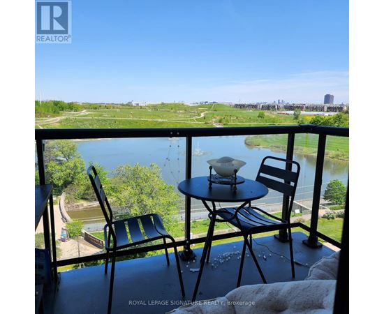 A balcony with a table and two chairs overlooking a river.