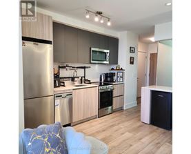A modern kitchen with wooden cabinets and stainless steel appliances.