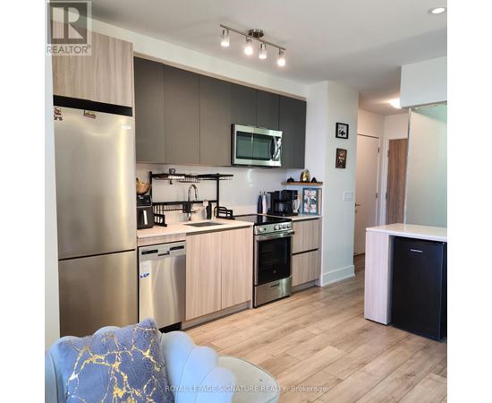 A modern kitchen with wooden cabinets and stainless steel appliances.