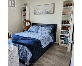 A bedroom with a bed, a dog, and a shelf with bags.