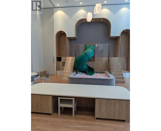 A slide in a play area with a green cover.