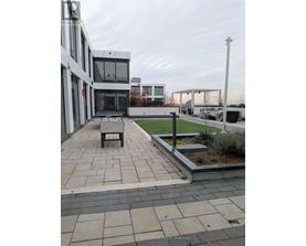 A modern building with a patio and a bench.