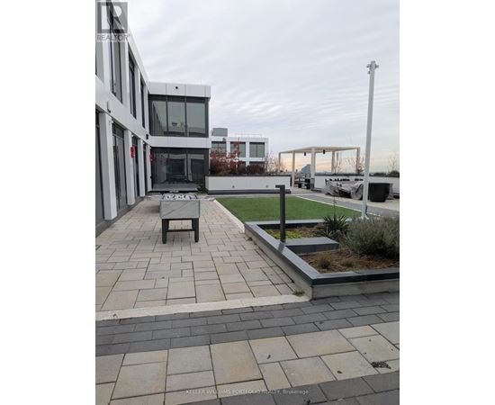 A modern building with a patio and a bench.