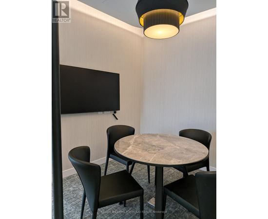 A conference room with a table, chairs, and a television.