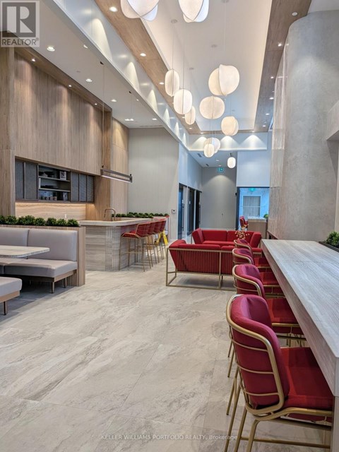 A modern dining area with red chairs and a long table.