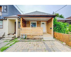 A small wooden house with a front porch and a white door.