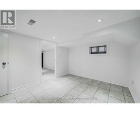 A spacious room with white walls and a tiled floor.