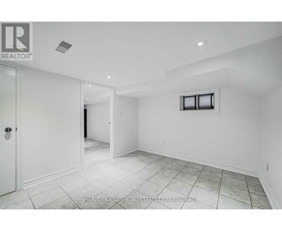 A spacious room with white walls and a tiled floor.