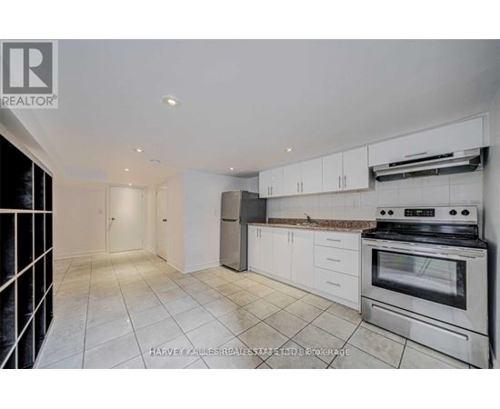 A kitchen with white cabinets and a stove top oven.
