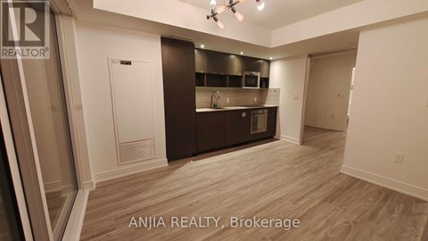 A well-lit, spacious kitchen area with wooden flooring and modern appliances.