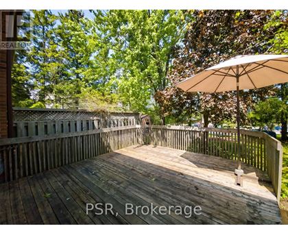 A wooden deck with a white umbrella and a sign that reads "PSR, Brokerage".