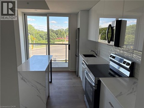 A kitchen with a marble countertop and stainless steel appliances.