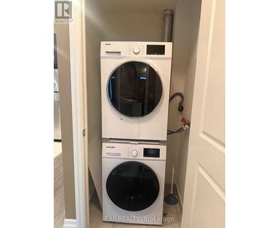 A white dryer and washer stacked on top of each other in a small space.