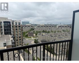 A view from a balcony overlooking a cityscape with buildings and a cloudy sky.