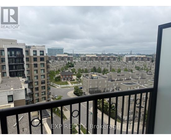 A view from a balcony overlooking a cityscape with buildings and a cloudy sky.