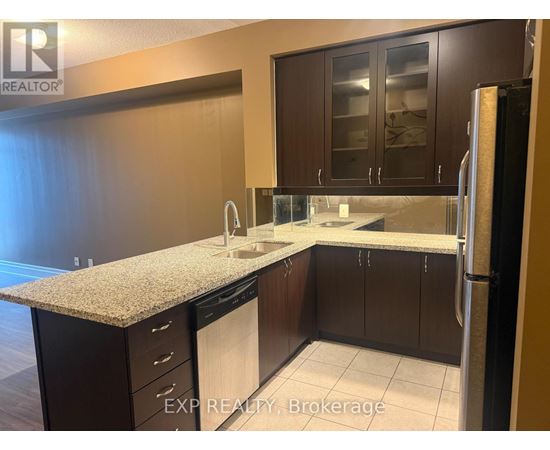 A kitchen with dark brown cabinets and a granite countertop.