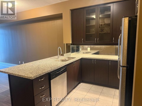 A kitchen with dark brown cabinets and a granite countertop.