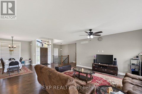 A living room with a brown leather couch and a flat screen TV.