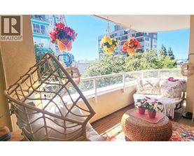 A balcony with a chair and a table with flowers.