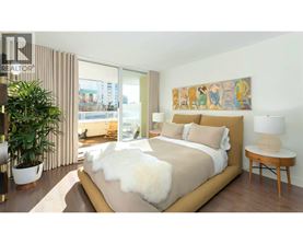 A bedroom with a large bed and a painting on the wall.