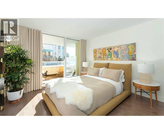A bedroom with a large bed and a painting on the wall.