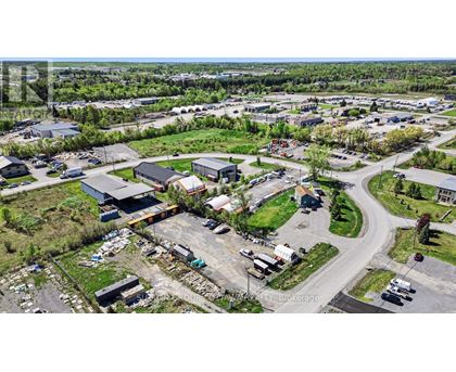 An aerial view of a parking lot with several cars and buildings.