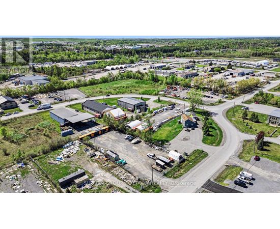 An aerial view of a parking lot with several cars and buildings.