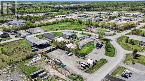 An aerial view of a parking lot with several cars and buildings.