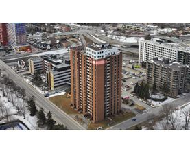 A tall brown building is in the middle of a snowy street.