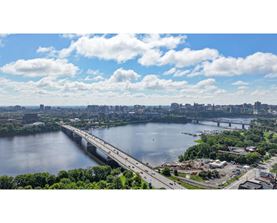 A bridge spans a large body of water with a city in the background.