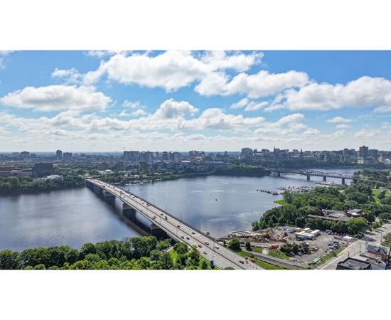 A bridge spans a large body of water with a city in the background.