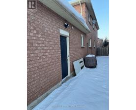 A red brick house with a black door and a white door.